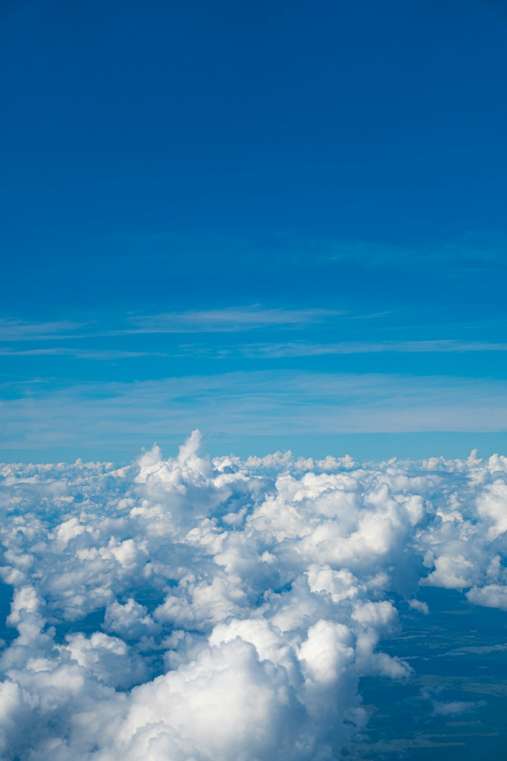 空の雲の上を高く飛ぶ飛行機