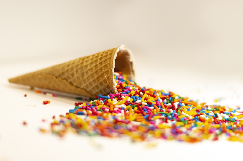 an ice cream cone filled with sprinkles and colored sprinkles