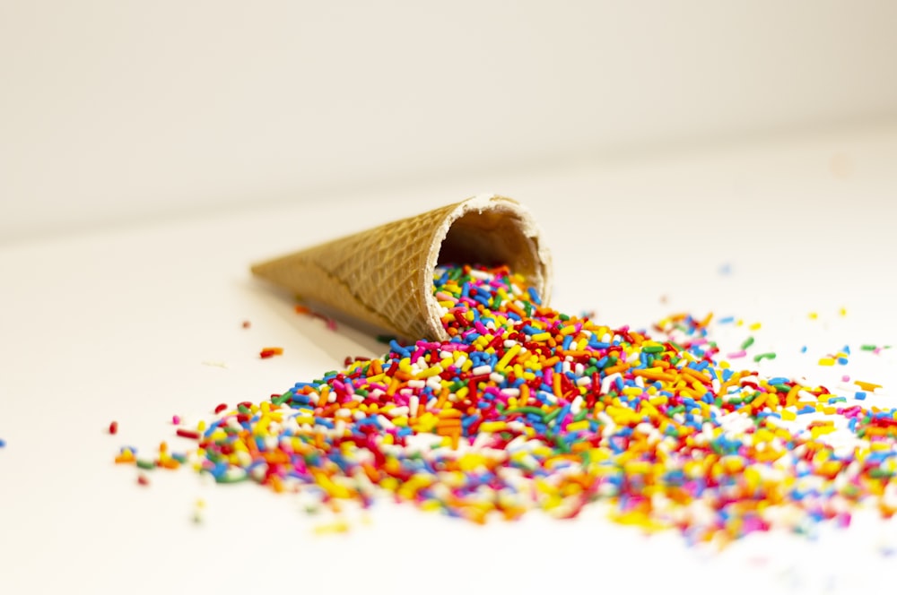 a cone filled with sprinkles on top of a table