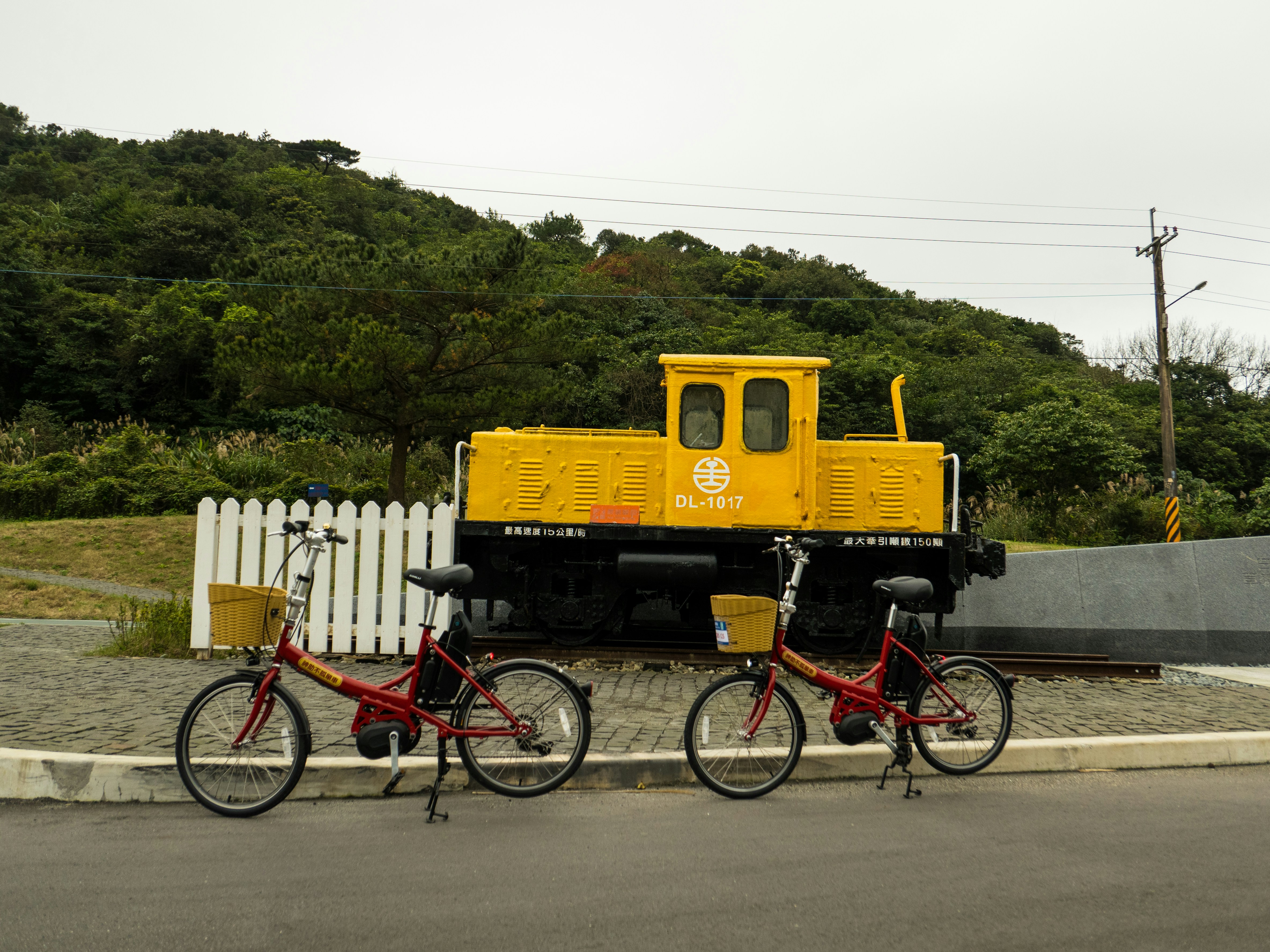 a couple of bikes parked next to a yellow train