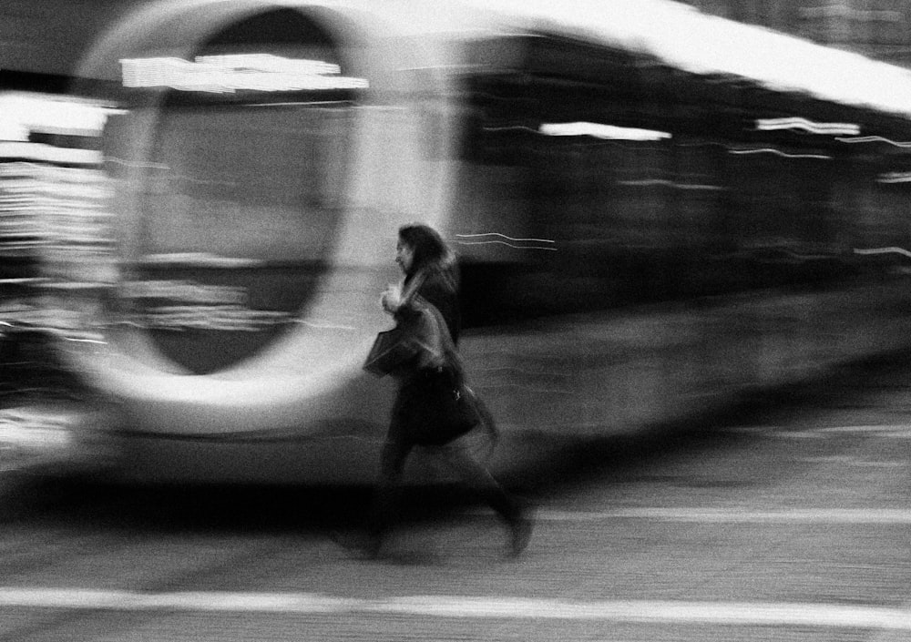 a woman walking down a street past a train