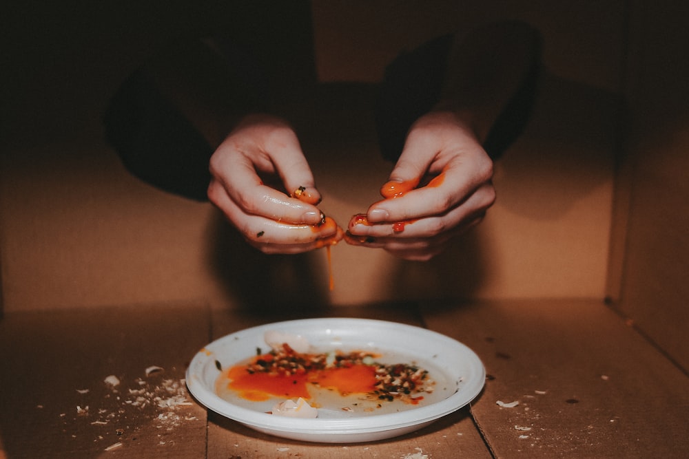 a person holding a spoon over a plate of food