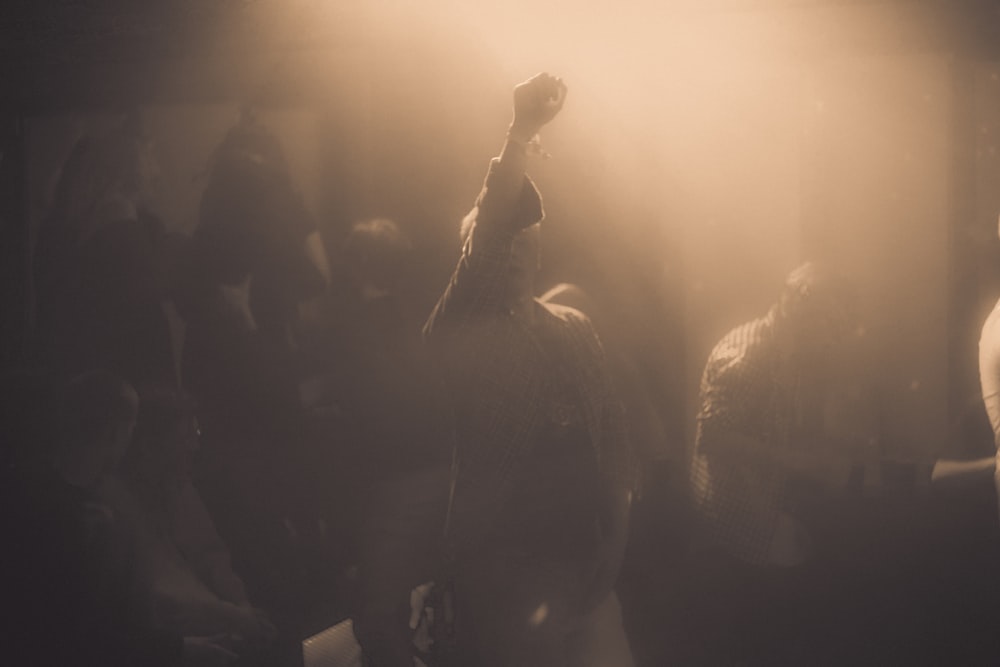 a group of people standing around in a dark room