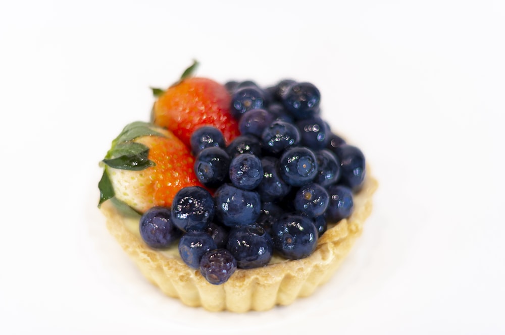 a close up of a pastry topped with blueberries and strawberries
