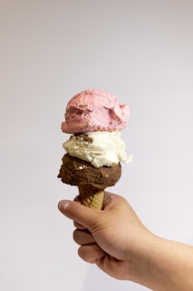 a hand holding a scoop of ice cream