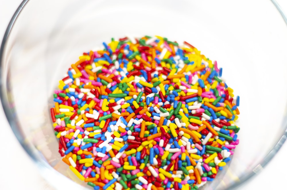 a glass bowl filled with sprinkles on top of a table