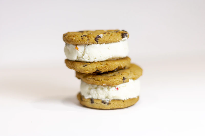 Two chocolate chip cookie ice cream sandwiches stacked up