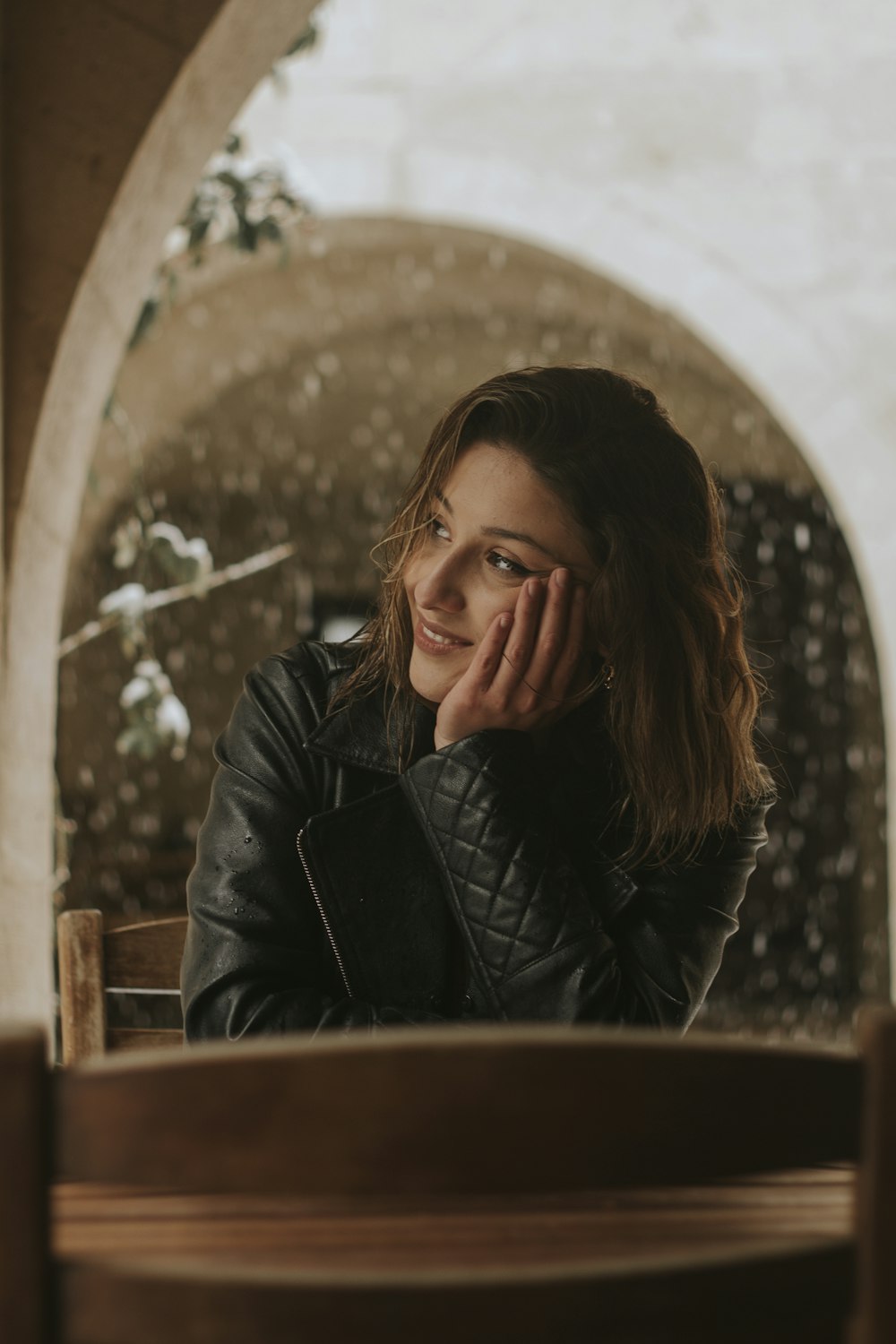 a woman sitting at a table with her hand on her face