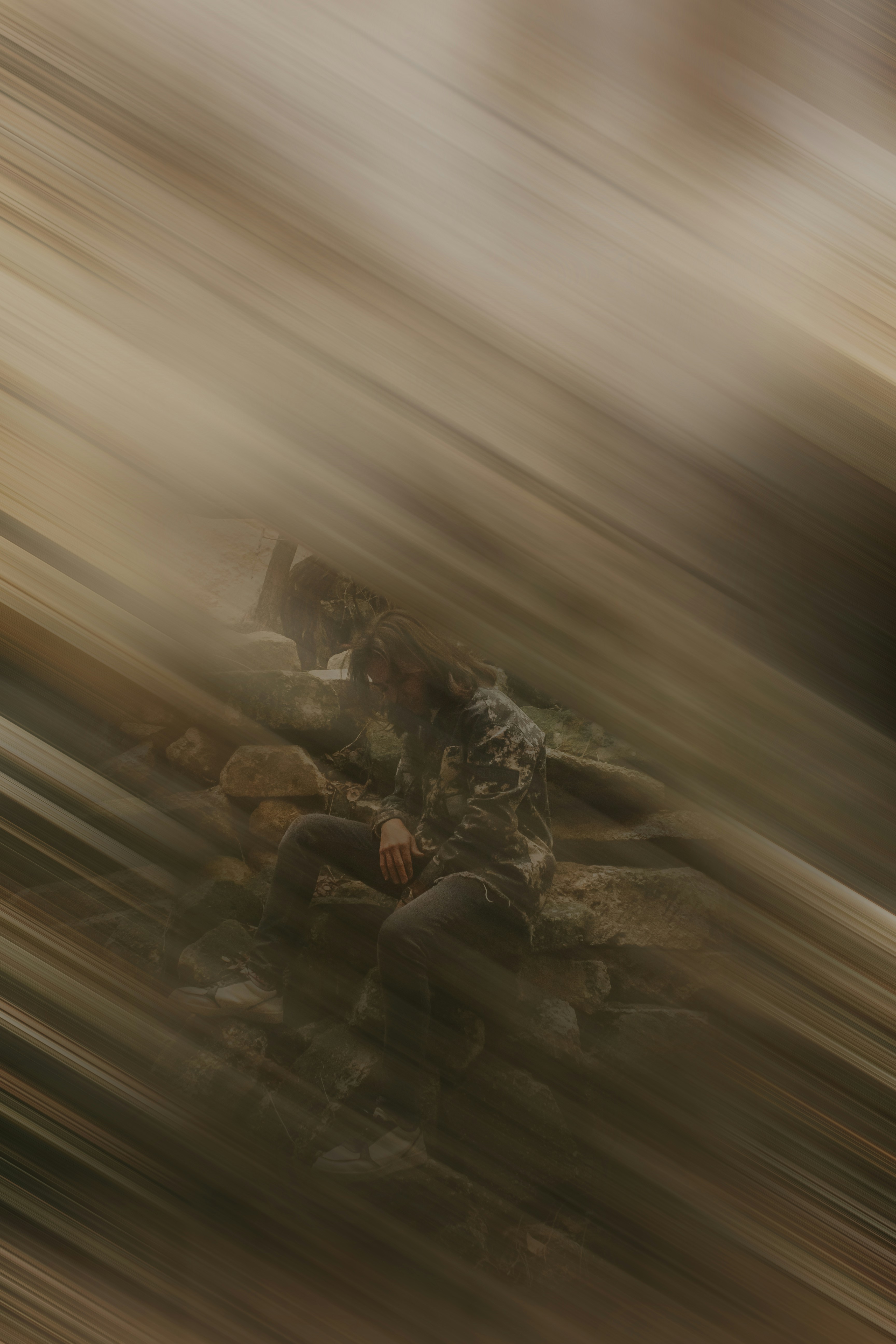 a blurry photo of a person sitting on a rock