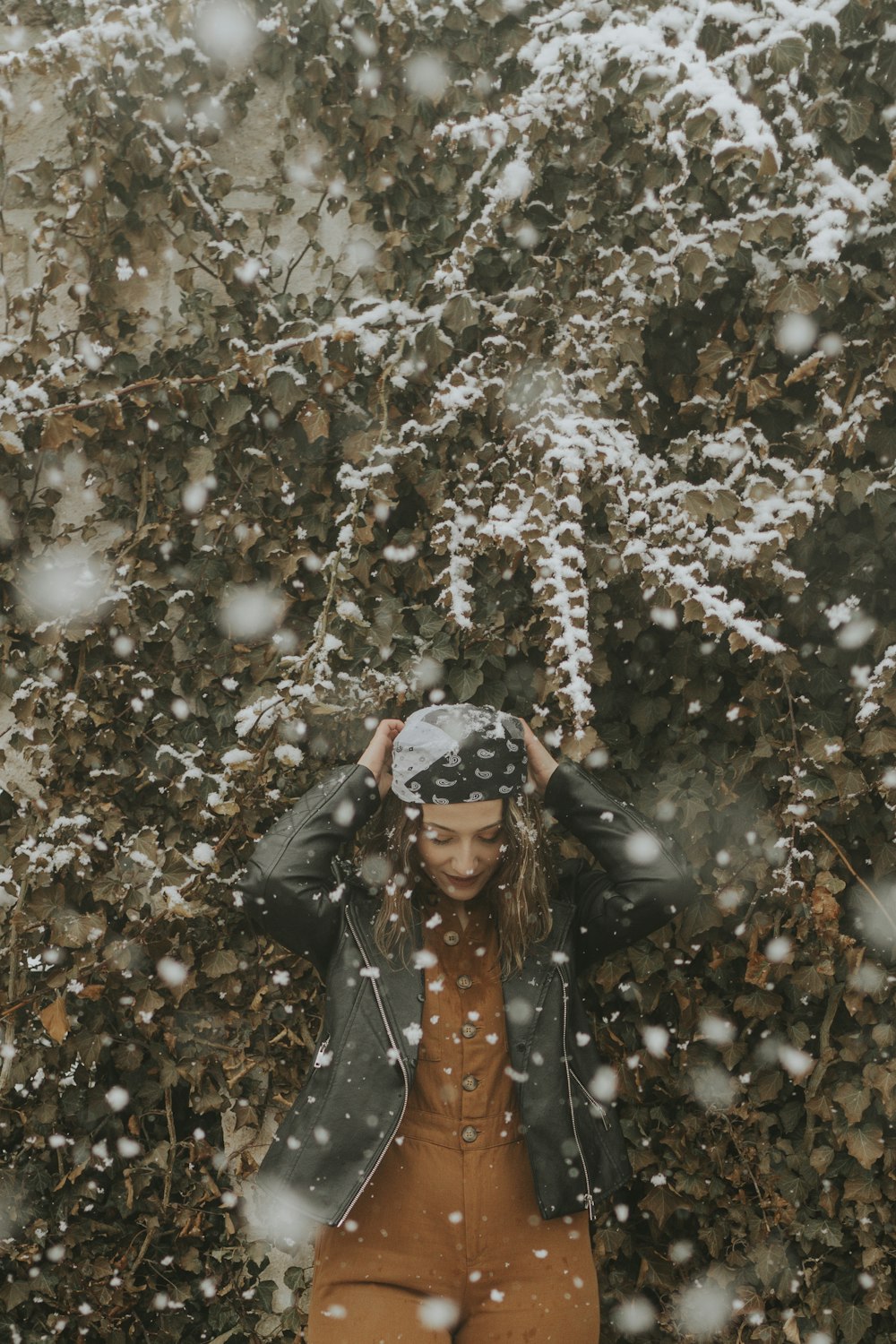 a woman standing in front of a tree covered in snow