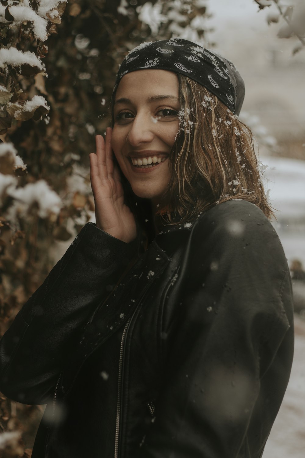 a woman standing in front of a tree covered in snow