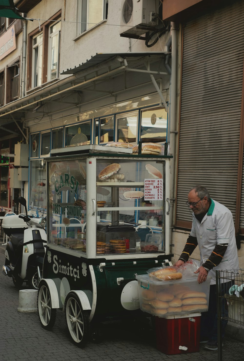 Un uomo in piedi davanti a un carrello di cibo