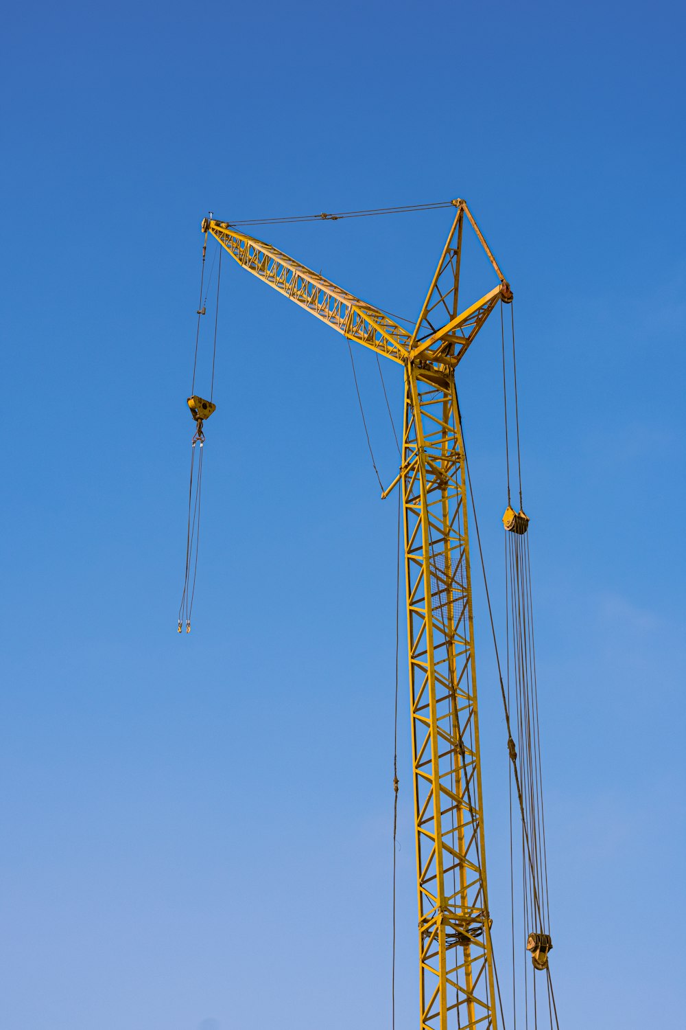 a yellow crane is on a clear blue sky