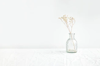 Close-up of a stone vase on a cream linen tablecloth.