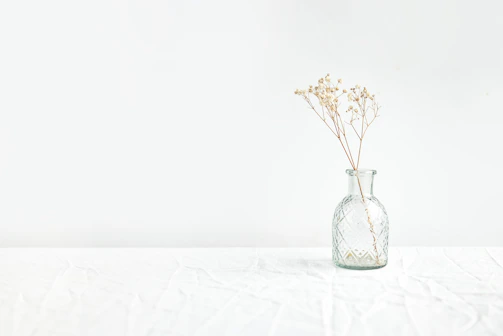 Close-up of a stone vase on a cream linen tablecloth.
