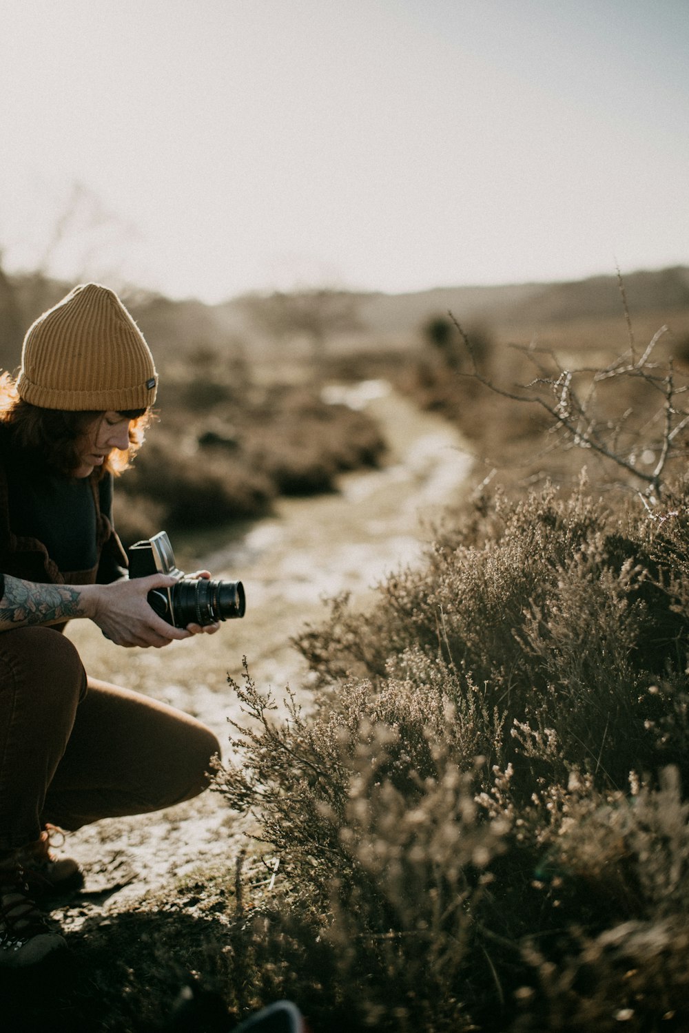 a woman kneeling down with a camera in her hand