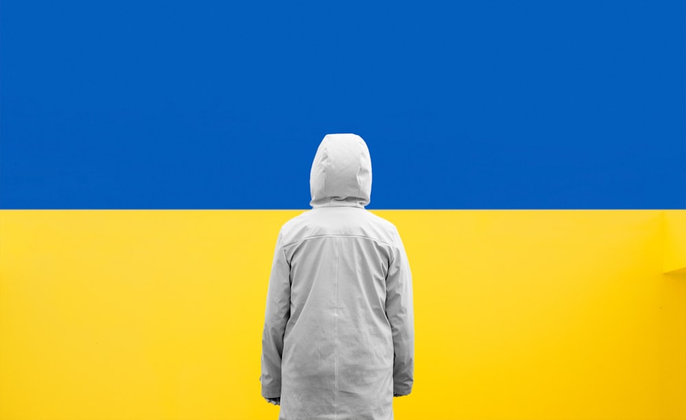 une personne debout devant un mur bleu et jaune