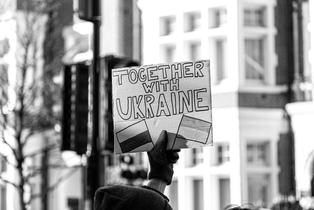 a person holding a sign that says together with ukraine