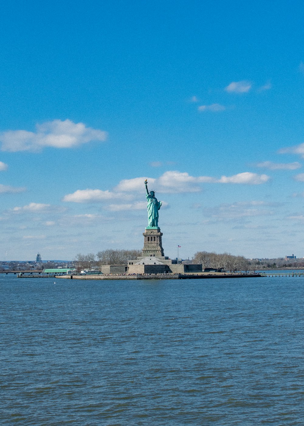 a large body of water with a statue of liberty in the background