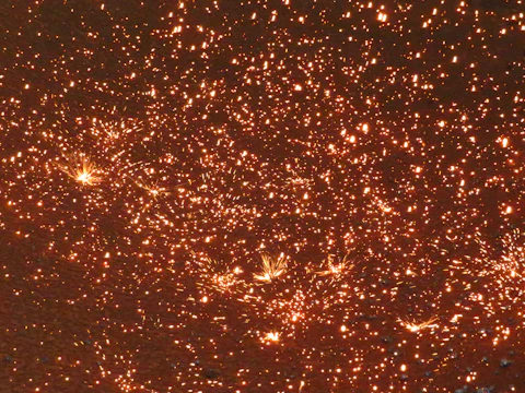 Close-up of golden sparks cascading down like a shimmering waterfall.