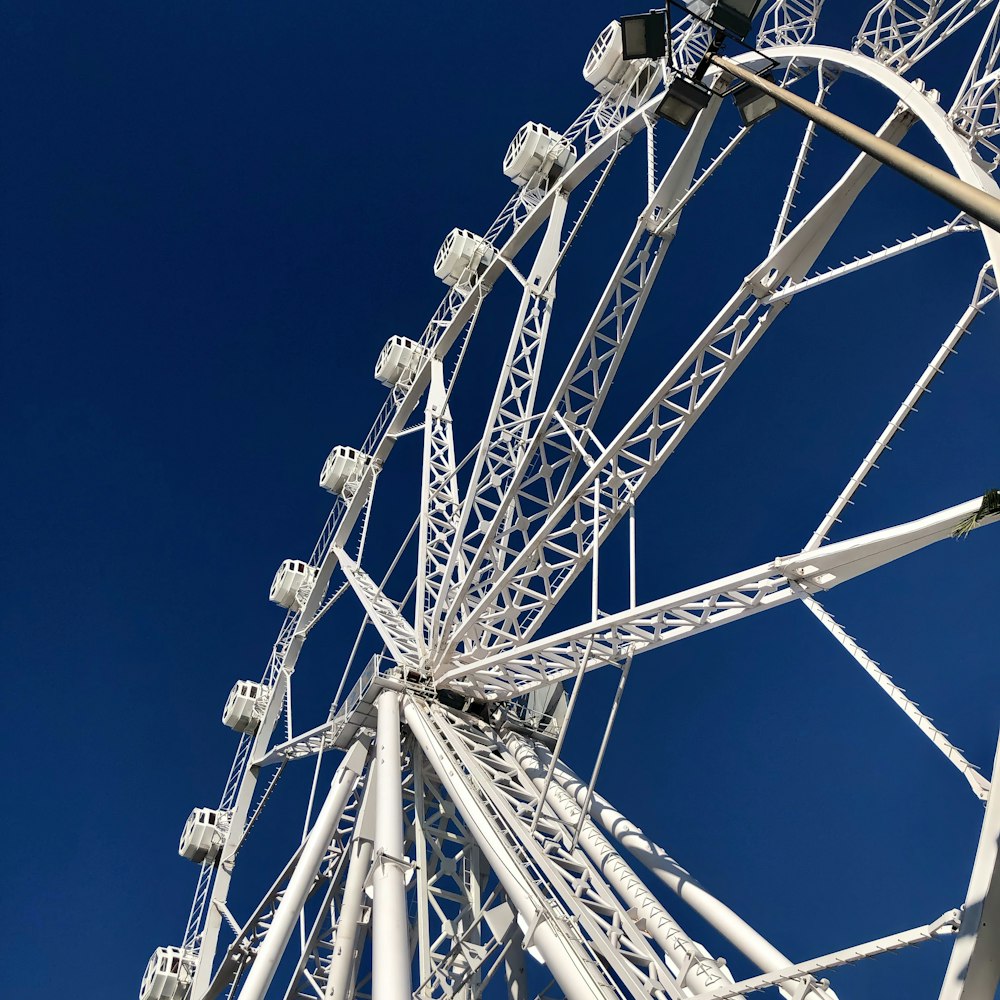 a white ferris wheel against a blue sky