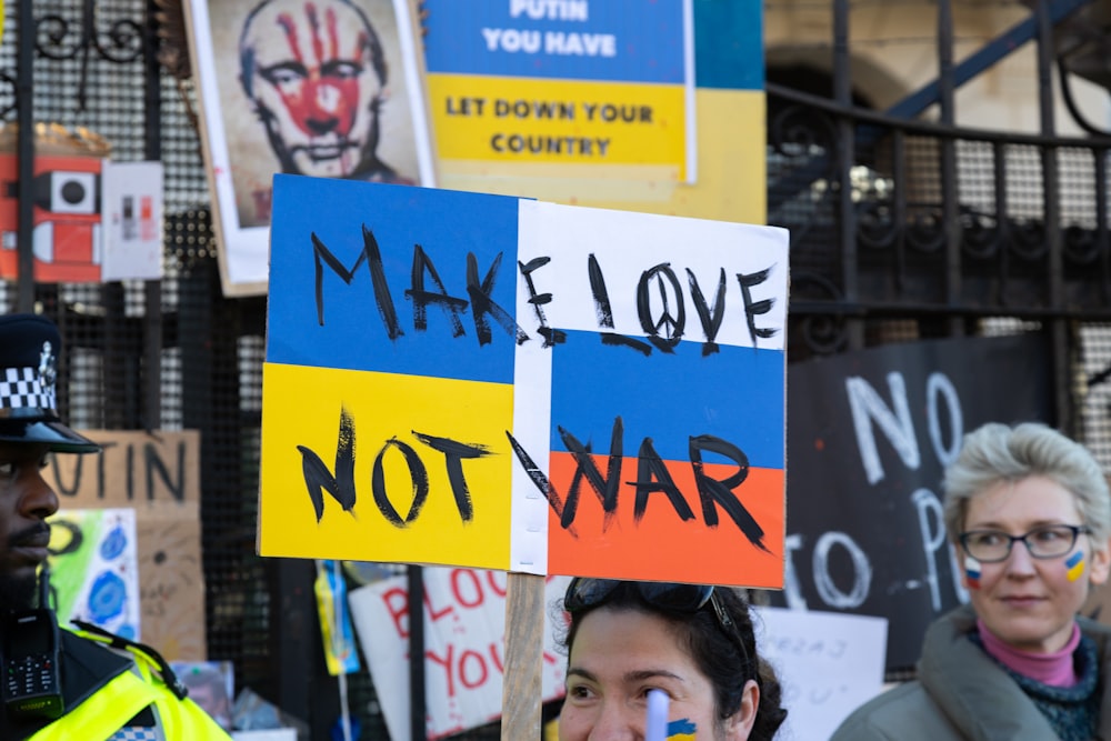 a man holding a sign that says make love not war