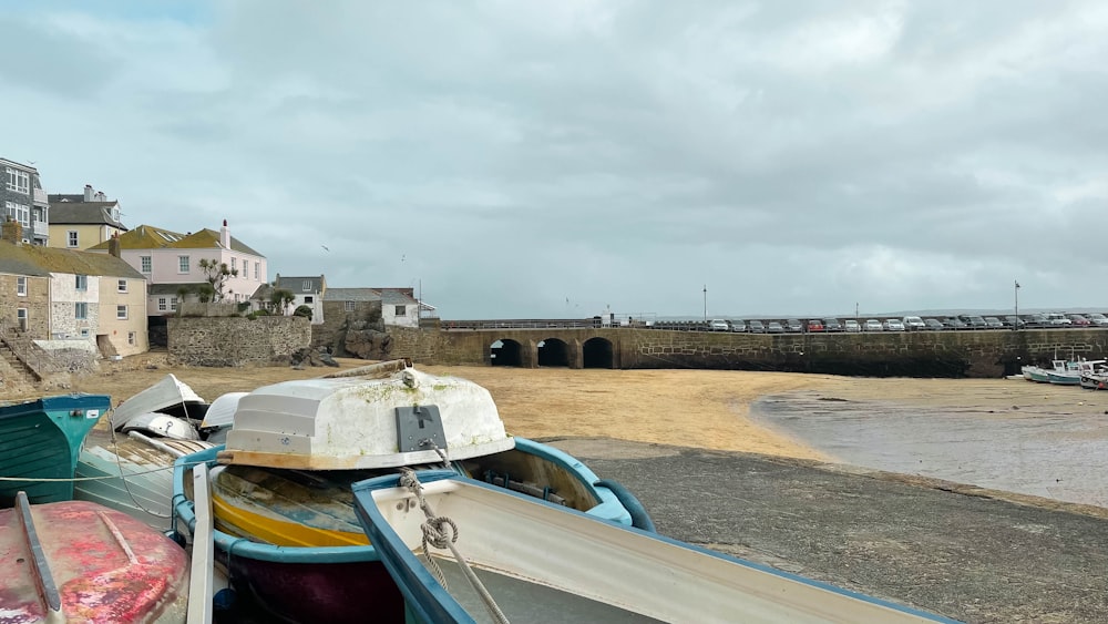 a row of boats sitting on top of a sandy beach