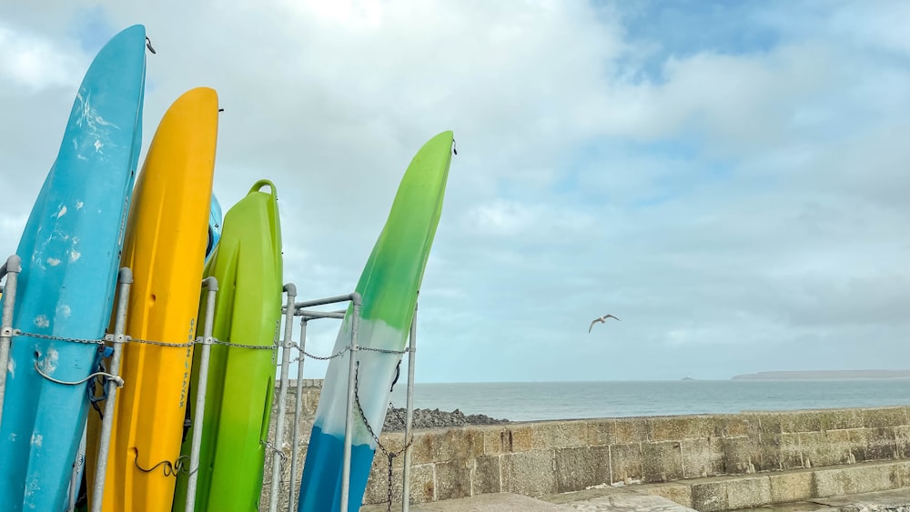 a row of surfboards sitting next to the ocean