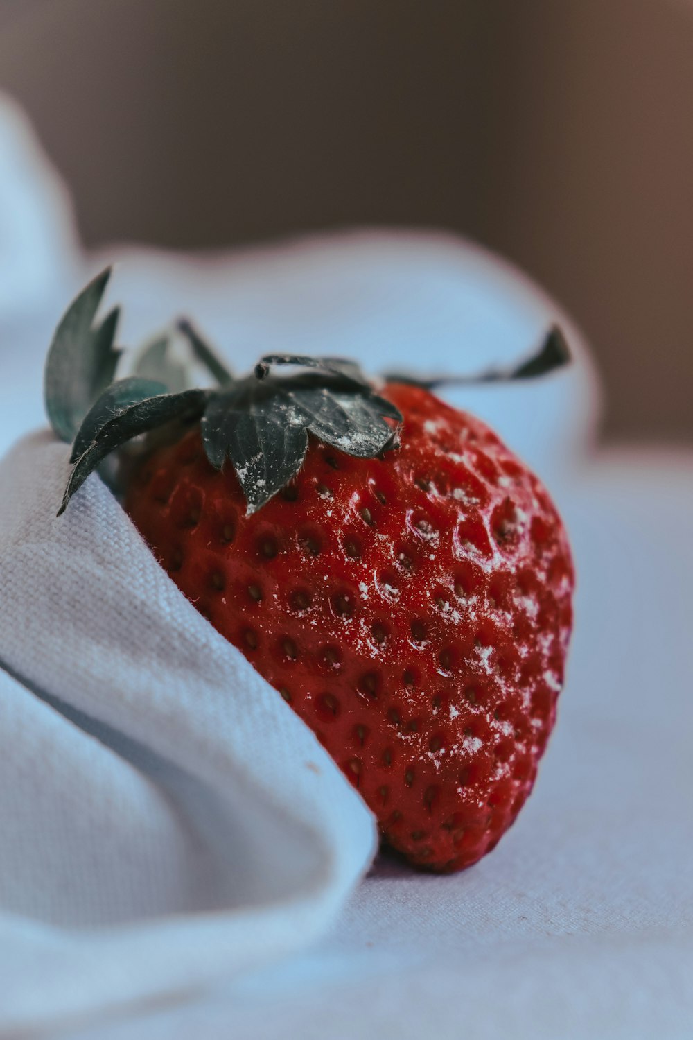 a close up of a strawberry on a white cloth