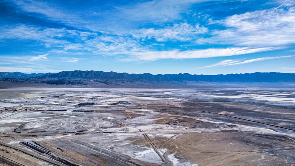 an aerial view of a desert with mountains in the background