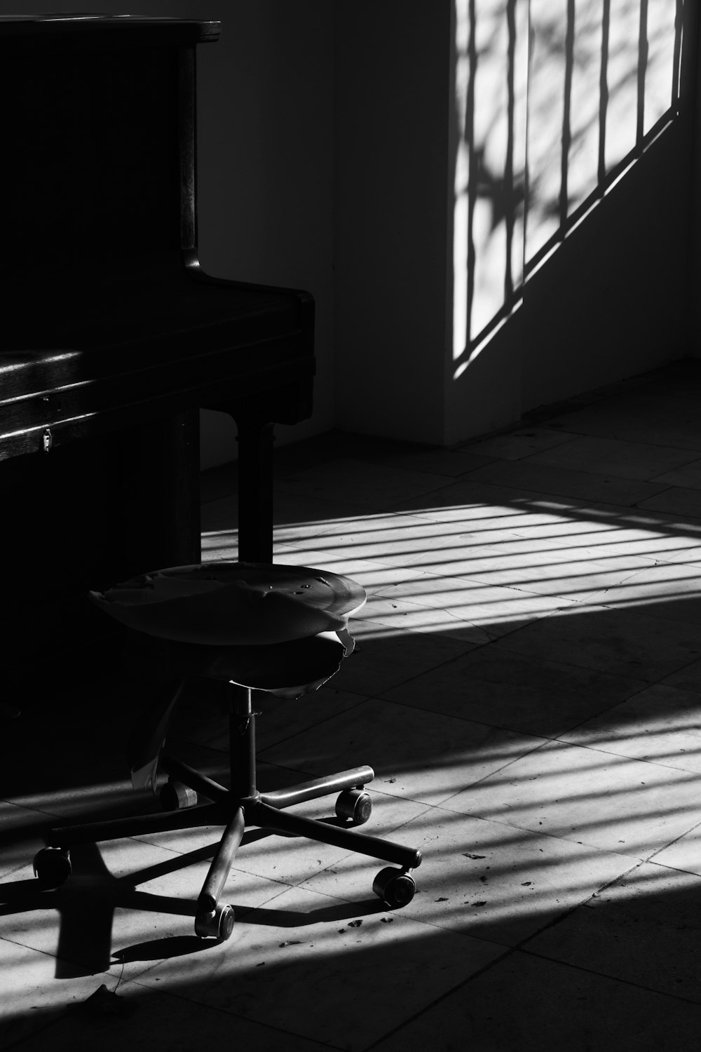 a black and white photo of a chair and a piano