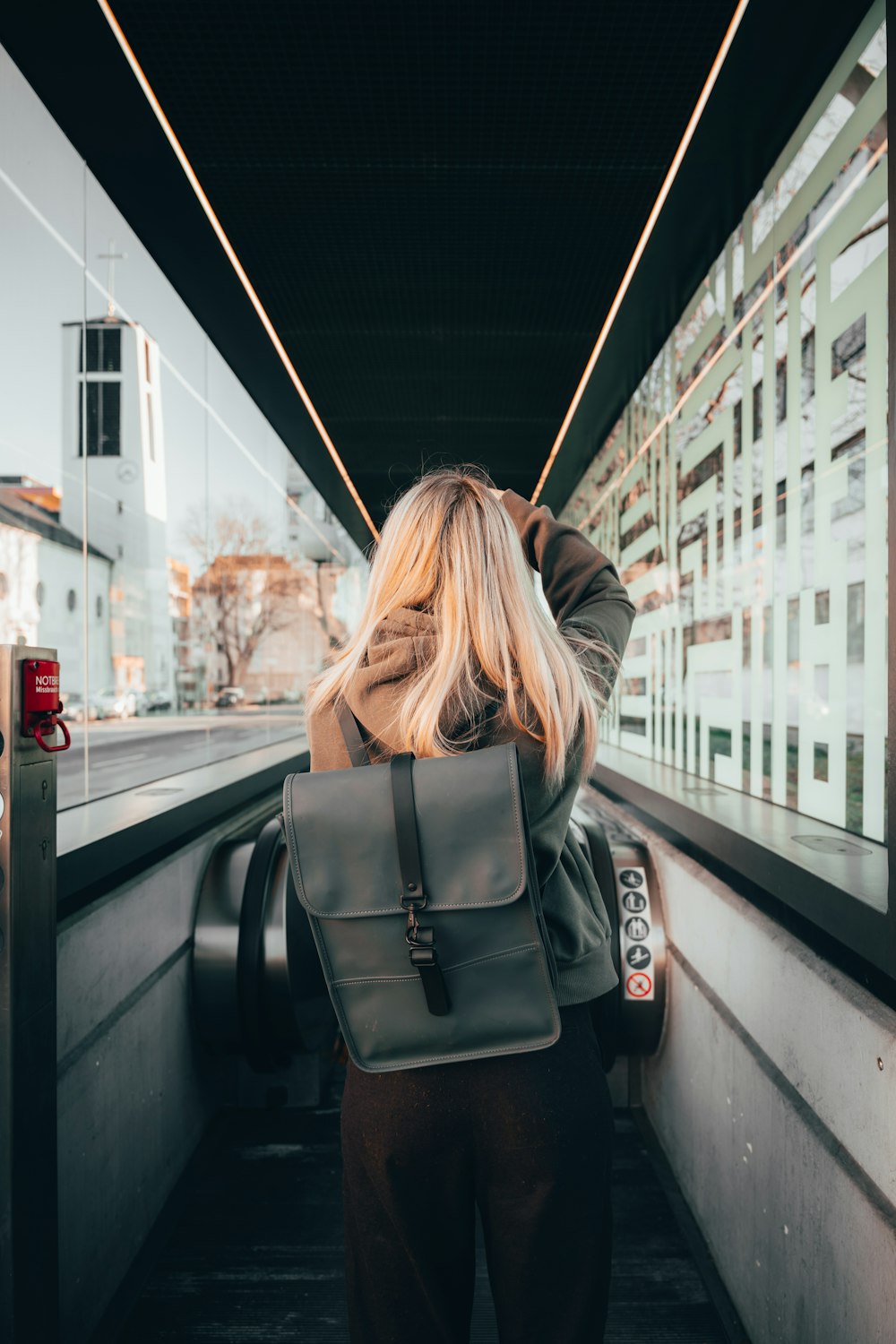 a woman with a backpack is looking out a window