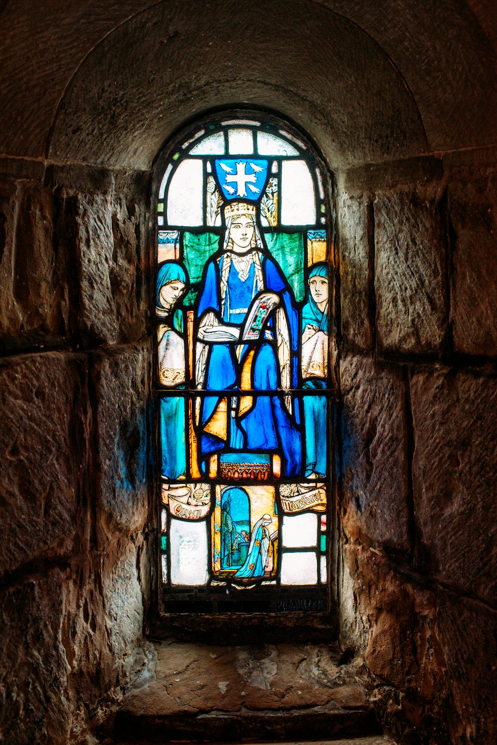 a stained glass window in a stone wall
