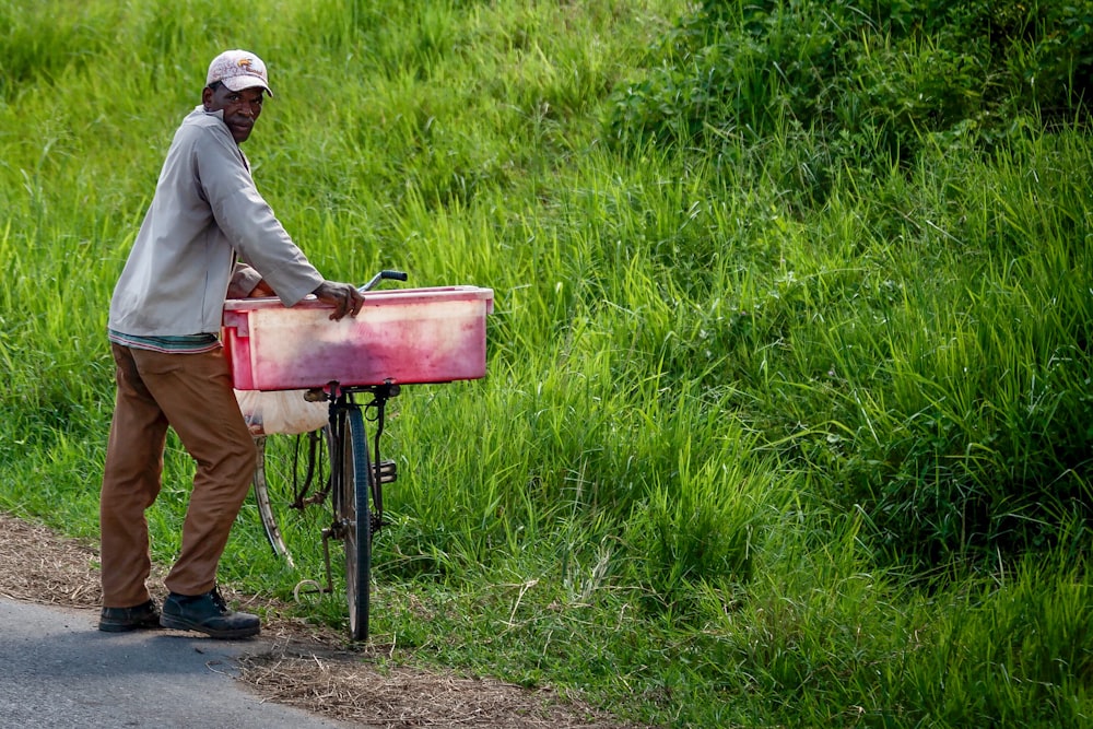 a man standing next to a bike on a road