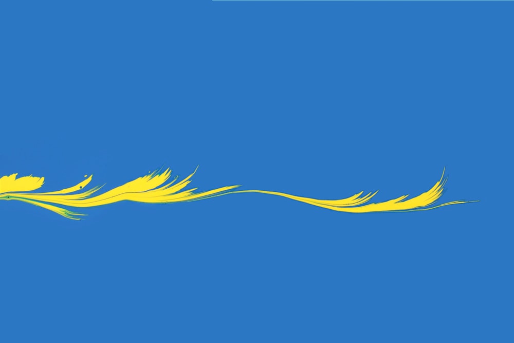a yellow bird flying in a blue sky