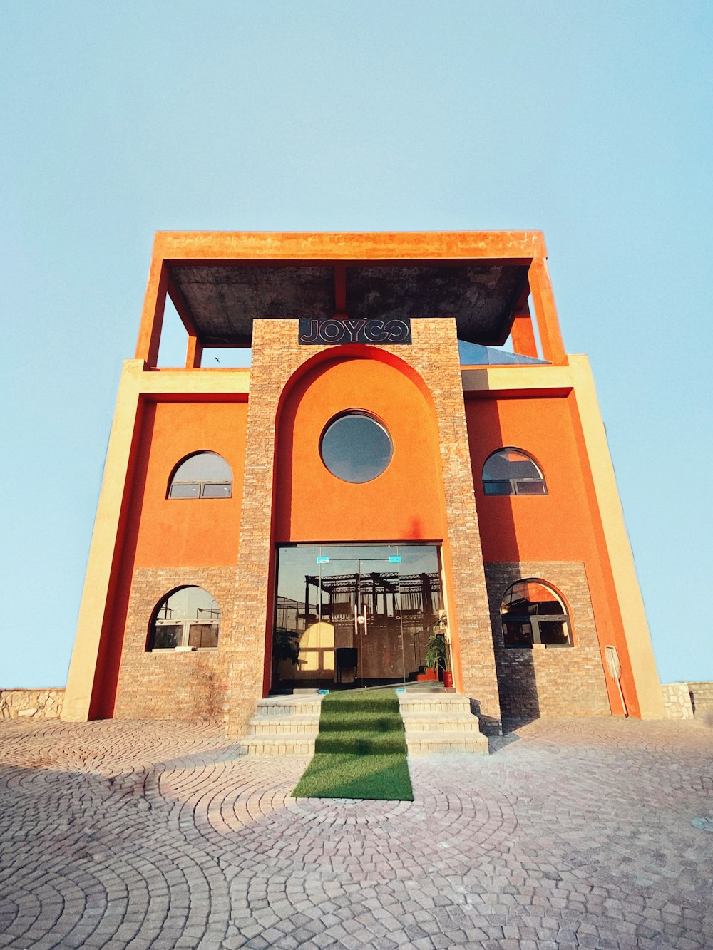 a large orange building with a clock on it's side