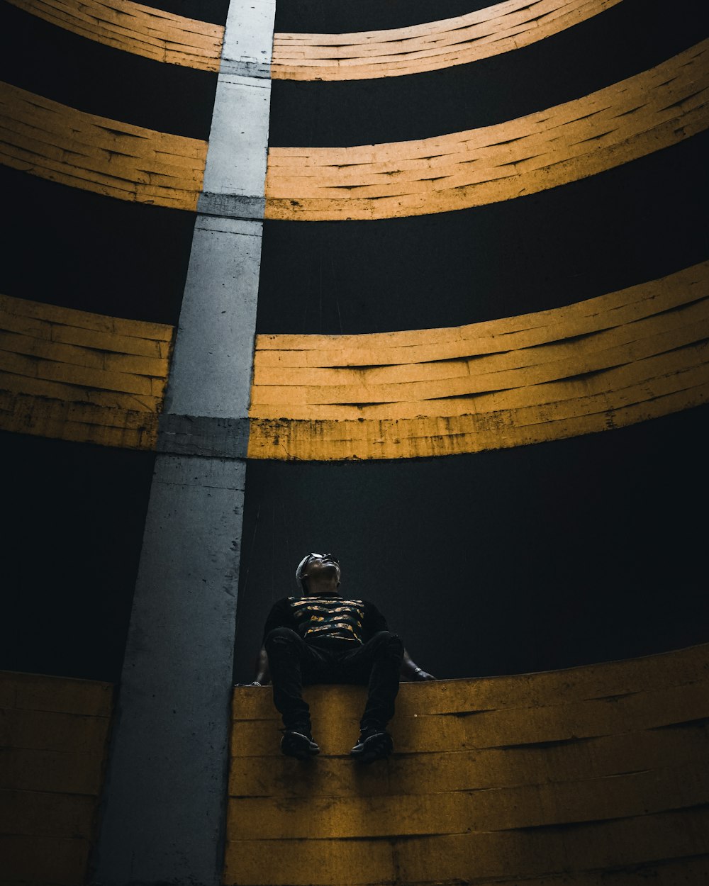 a man sitting on a ledge in the middle of a tunnel