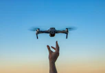 a hand holding a flying object in the air