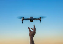 a hand holding a flying object in the air