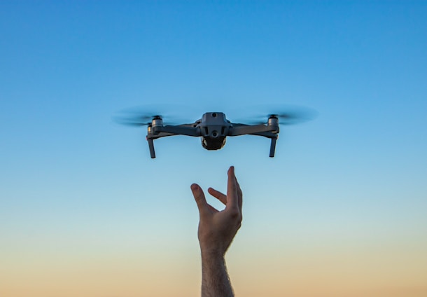 a hand holding a flying object in the air