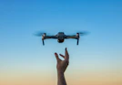 a hand holding a flying object in the air