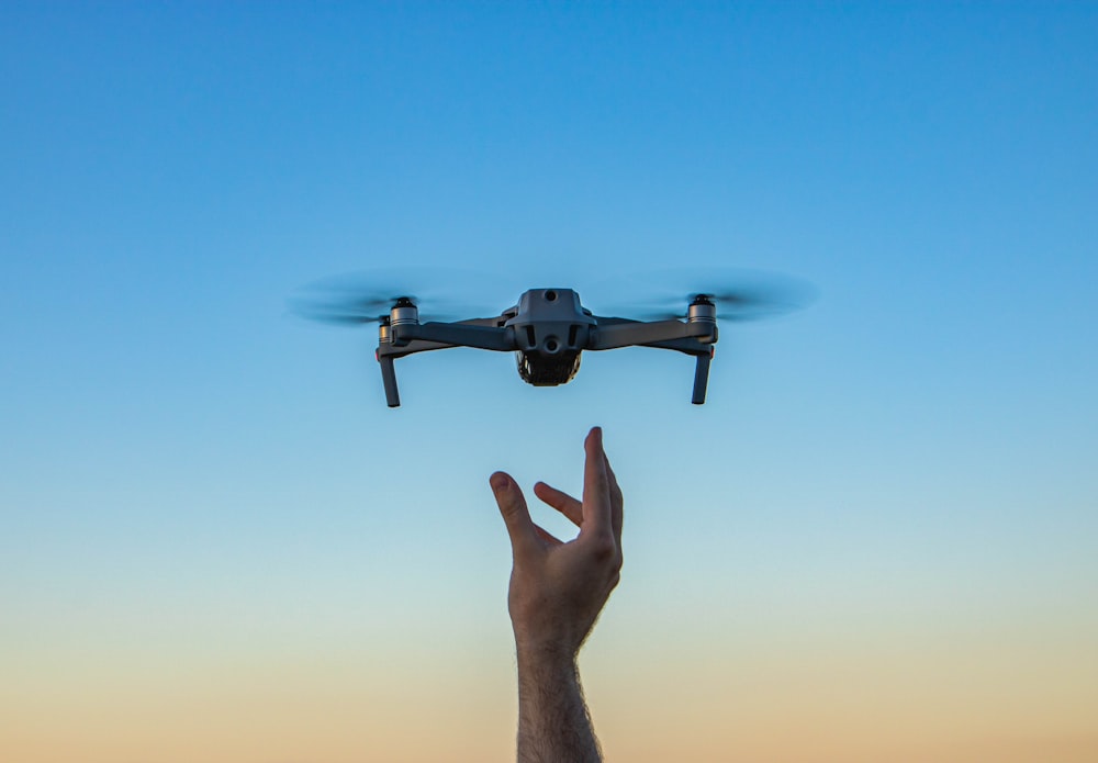 a hand holding a flying object in the air