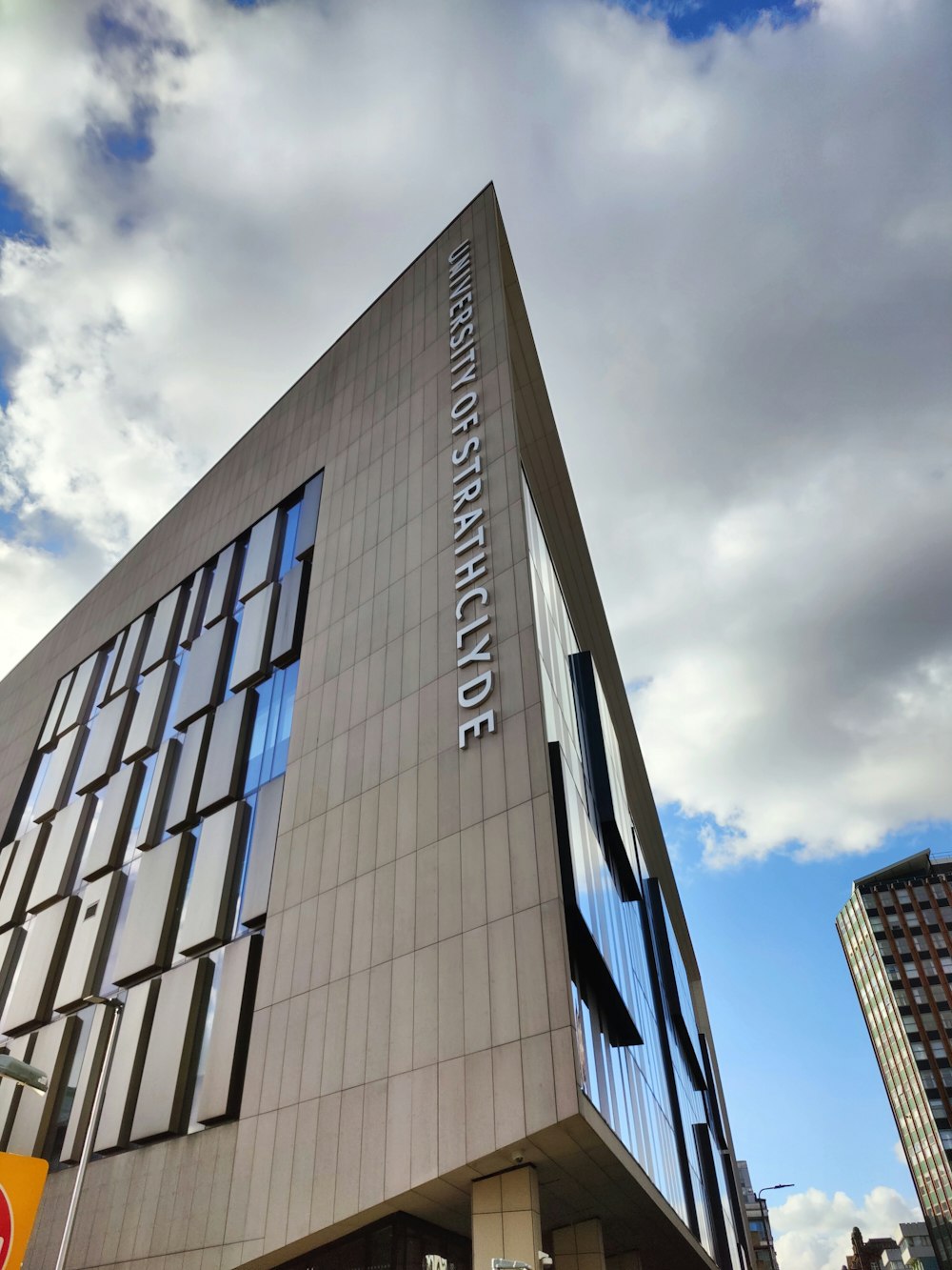 a tall building with windows and a sky background