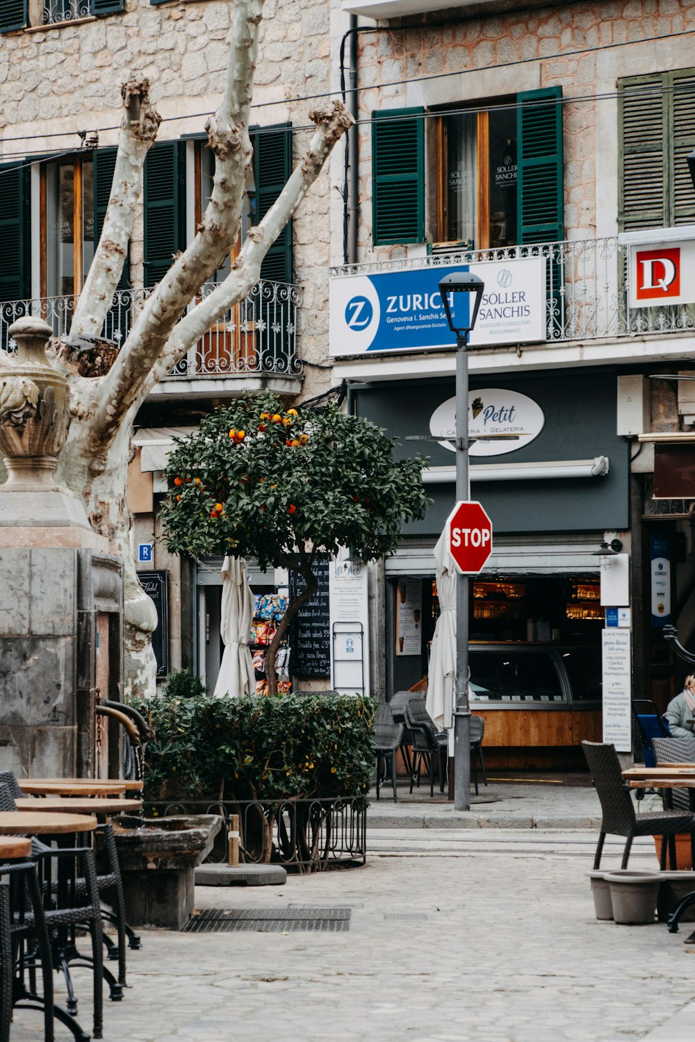 a group of people sitting at tables in a courtyard