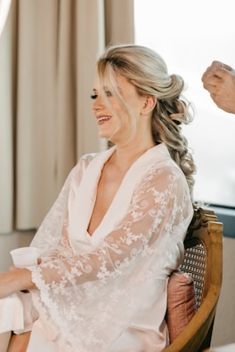 A smiling woman relaxing during a body contouring session in a modern clinic setting.