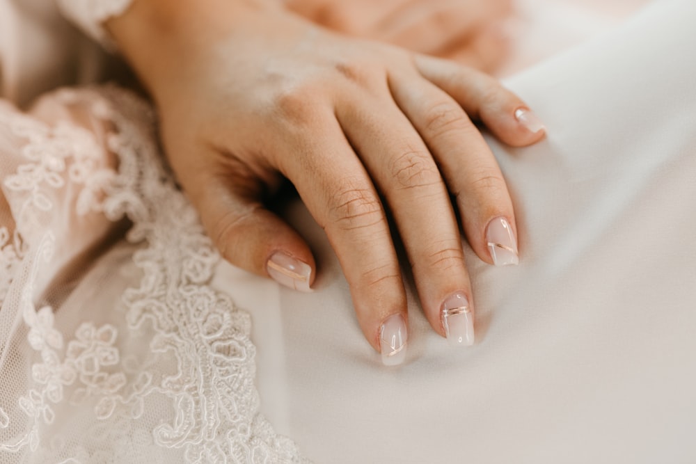 a close up of a person's hands on a bed