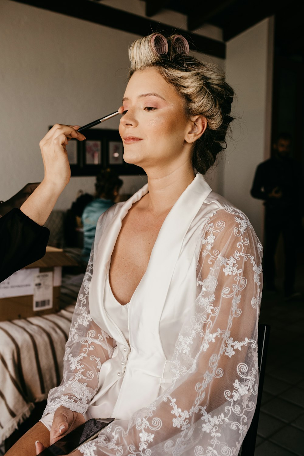 a woman getting her makeup done by a professional makeup artist