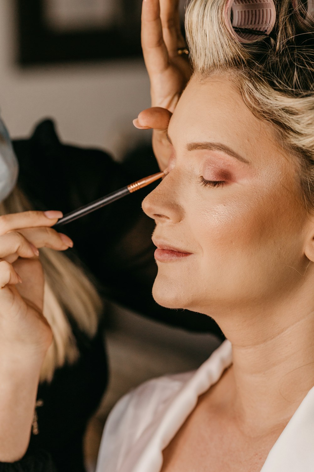 a woman is getting her make up done