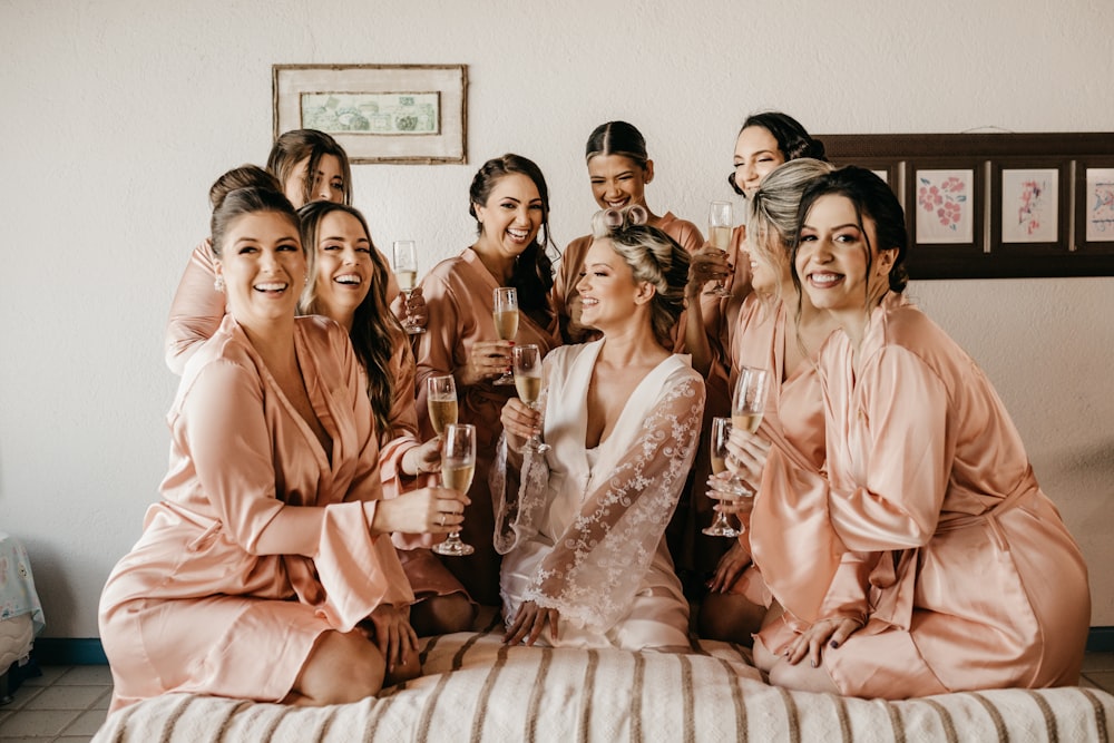 a group of women sitting on top of a bed