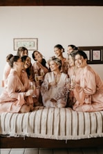 a group of women sitting on top of a bed